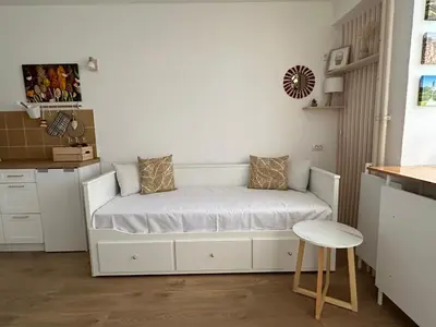 a small bedroom with a bed and a stool at NiNiNo in Belgrade