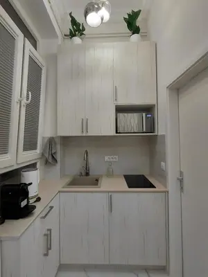a kitchen with white cabinets and a sink at Angel Suites in Belgrade