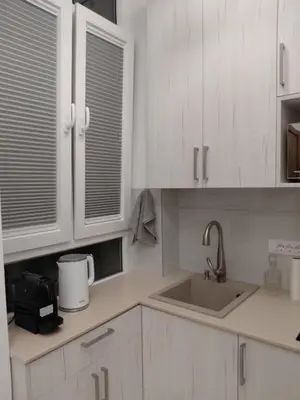 a white kitchen with white cabinets and a sink at Angel Suites in Belgrade