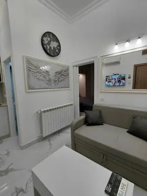 a living room with a couch and a clock on the wall at Angel Suites in Belgrade