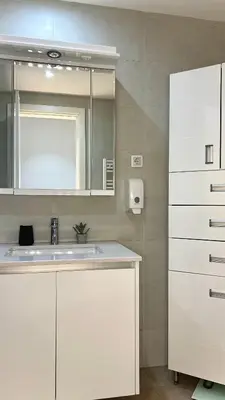 a white bathroom with a sink and a mirror at Belgrade Waterfront Lux Apartments in Belgrade