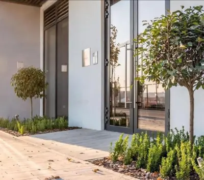 a facade of a building with glass doors and trees at Belgrade Waterfront Lux Apartments in Belgrade