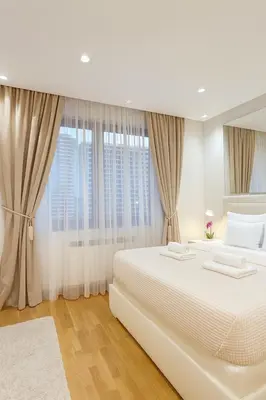 a white bedroom with a large bed and windows at Belgrade Waterfront Lux Apartments in Belgrade