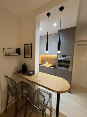 a kitchen with a wooden table and chairs in a room at Urban Nest Belgrade in Belgrade