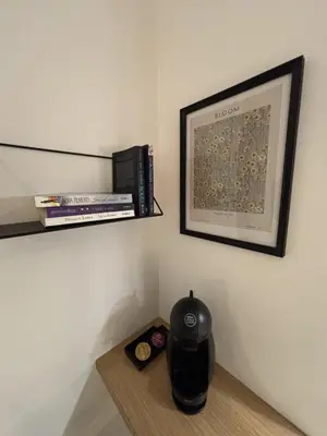a shelf with books and a vase on a table at Urban Nest Belgrade in Belgrade