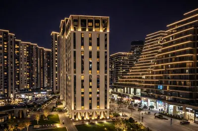 a tall white building in a city at night at Aria BW Lux Apartment in Belgrade