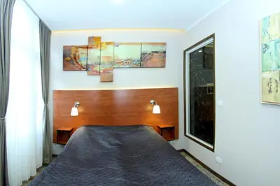 a bedroom with a bed and three paintings on the wall at Gala Luxury Suites in Belgrade