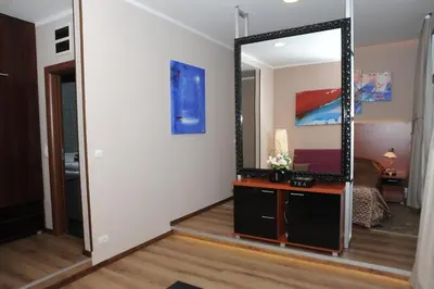 a room with a mirror and a dresser and a bedroom at Gala Luxury Suites in Belgrade