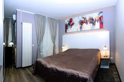 a bedroom with a bed and a painting on the wall at Gala Luxury Suites in Belgrade
