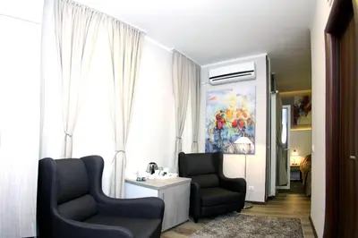 a living room with two chairs and a window at Gala Luxury Suites in Belgrade