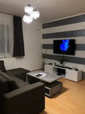 a living room with a couch and a flat screen tv at Apartman Lav in Bele Vode