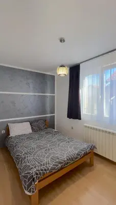 a bedroom with a bed with a gray wall at Apartman Lav in Bele Vode