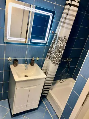 a blue tiled bathroom with a sink and a shower at Apartman Lav in Bele Vode