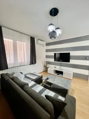 a living room with a couch and a flat screen tv at Apartman Lav in Bele Vode