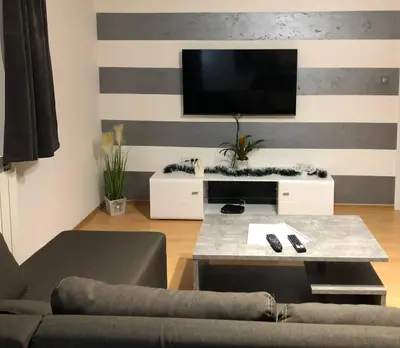 a living room with a tv on a striped wall at Apartman Lav in Bele Vode