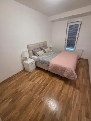 a bedroom with a bed and a wooden floor at Wolf's Wonder in Obrenovac