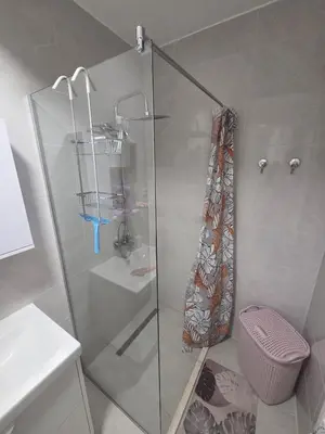 a shower with a glass door in a bathroom at Wolf's Wonder in Obrenovac