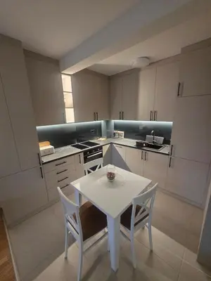 a kitchen with a white table and chairs in it at Wolf's Wonder in Obrenovac