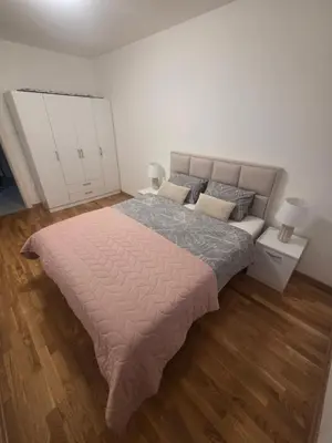 a bedroom with a large bed and wooden floors at Wolf's Wonder in Obrenovac