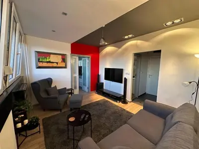 a living room with a couch and a tv at Temple View Vračar Apartment in Belgrade