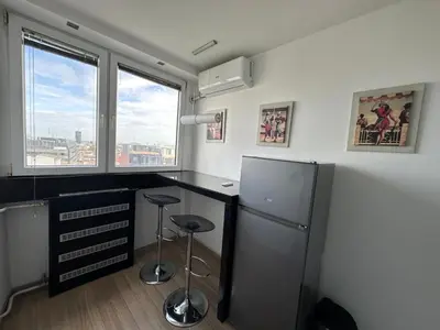 a kitchen with a refrigerator and two stools in it at Temple View Vračar Apartment in Belgrade