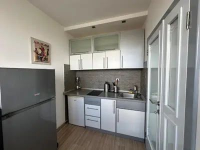 a kitchen with white cabinets and a stainless steel sink at Temple View Vračar Apartment in Belgrade