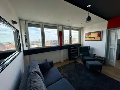 a living room with a couch and chairs and windows at Temple View Vračar Apartment in Belgrade