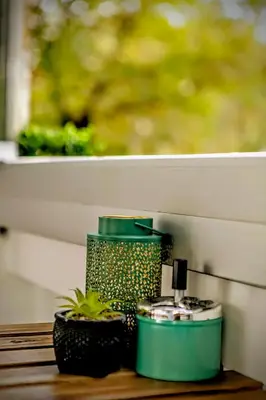a green container sitting on a table next to a window at Slavija Central in Belgrade