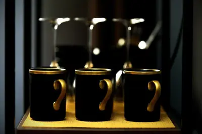 three black and gold cups sitting on a table at Slavija Central in Belgrade