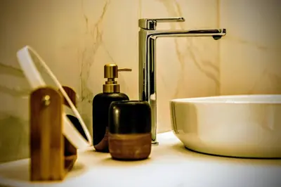 a bathroom counter with two bottles of soap and a sink at Slavija Central in Belgrade