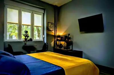 a bedroom with a bed with a yellow blanket on it at Slavija Central in Belgrade