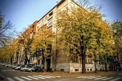 a building with cars parked on the side of a street at Slavija Central in Belgrade