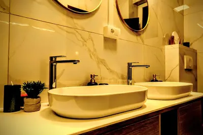 a bathroom with a large white sink and mirrors at Slavija Central in Belgrade