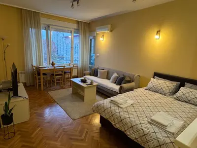 a room with a bed and a couch and a table at Apartment 63 in Belgrade