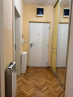 a hallway with a white door and a refrigerator at Apartment 63 in Belgrade