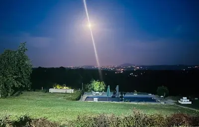 a beam of light in the sky above a pool at Kosmaj-Suncani Breg