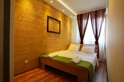 a bedroom with a bed with a wooden wall at Apartment Dositejeva 13 in Belgrade
