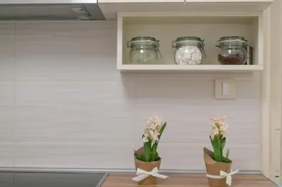 a shelf with three jars and flowers on it at Apartment Dositejeva 13 in Belgrade