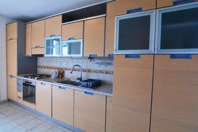 a large kitchen with wooden cabinets and a sink at Apartment Dositejeva 13 in Belgrade