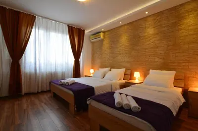 a hotel room with two beds and a window at Apartment Dositejeva 13 in Belgrade