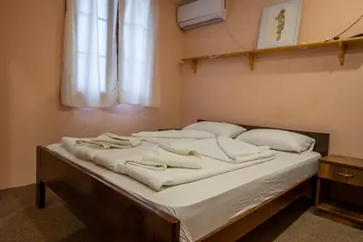 a bed in a room with white sheets and pillows at Etno kompleks Deliblatska Čarda in Deliblato
