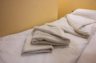 a pile of towels sitting on top of a bed at Etno kompleks Deliblatska Čarda in Deliblato