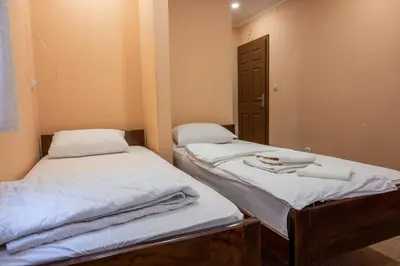 two twin beds in a room with a mirror at Etno kompleks Deliblatska Čarda in Deliblato