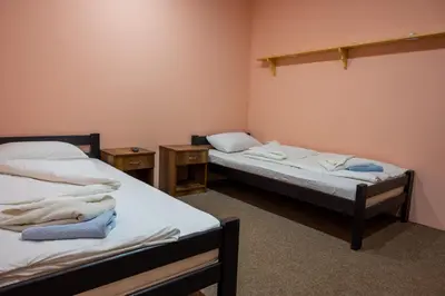 two twin beds in a room with two tables at Etno kompleks Deliblatska Čarda in Deliblato