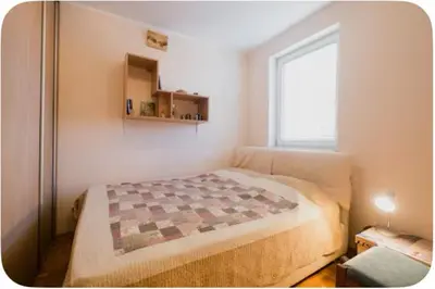 a bedroom with a bed with a quilt on it at Warm and comfortable two rooms flat in Belgrade