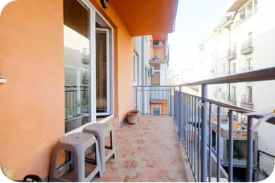 a balcony of a building with two stools at Warm and comfortable two rooms flat in Belgrade