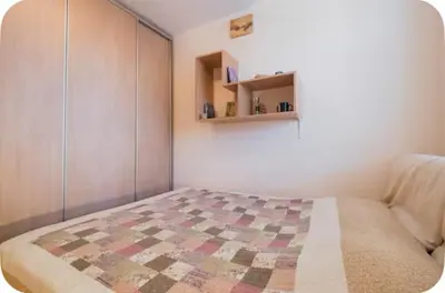 a bedroom with a bed with a quilt on it at Warm and comfortable two rooms flat in Belgrade
