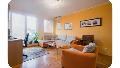 a living room with two couches and a tv at Warm and comfortable two rooms flat in Belgrade