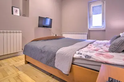 a bedroom with a bed and a tv on the wall at Kalemegdan Central Apartment II in Belgrade