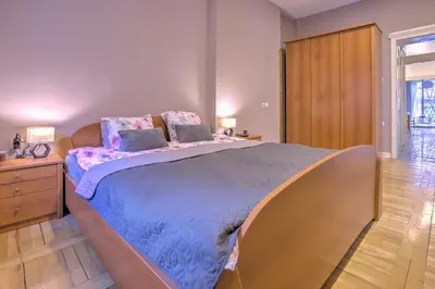 a bedroom with a large bed and a wooden cabinet at Kalemegdan Central Apartment II in Belgrade